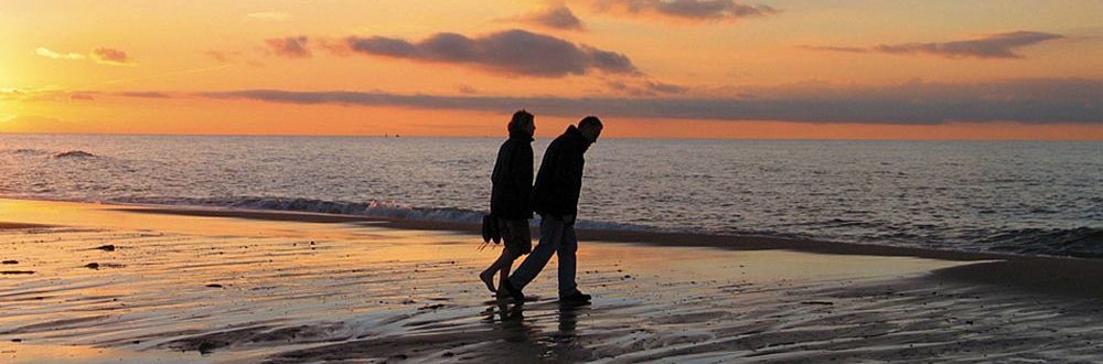 Thalasso - Die Kraft des Meeres im Wellnessurlaub - Hotel Neptun | Warnemünde Spaziergang am Strand vor Sonnenuntergang - Hotel Neptun | Warnemünde